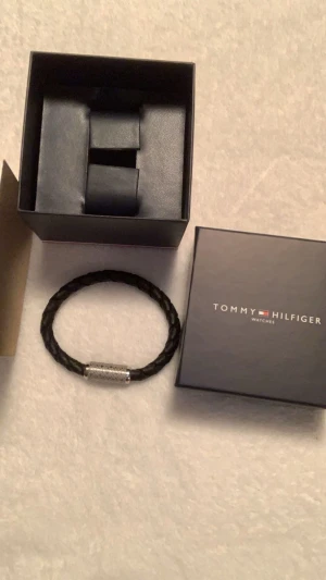 Tommy hilfiger armband - Svart o silver TH armband i läder, oanvänd, köptes för 1000 kr