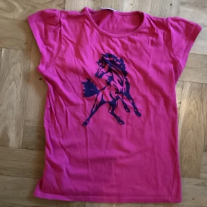 Rosa t-shirt med tryck - Söt rosa t-shorts med hästtryck. Liten storlek.