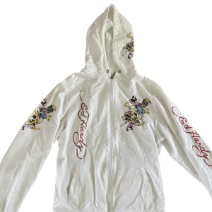 Ed Hardy Zip-up i nyskick  - Säljer nu en vit Ed-hardy zip-up med de coolaste detaljerna. Den är i väldigt bra skick och endast använd ett fåtal gånger. Säljer då det inte är min stil längre 🩷Strl S/M! Skriv gärna vid frågor eller intresse 👊(pris kan diskuteras)