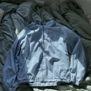 Blå o vit randig jacka med huva👍 - Randig jacka med huva och dragkedja. Använd fåtal gånger. Skick: 10/10 