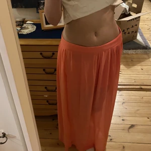 Somrig kjol - Jätte fin koral orange kjol  Perfekt till våren/ sommaren  Två snygga slitt vid vadera ben  Ny sick, andvänt fåtal gånger 