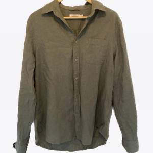 En grön linneskjorta helt oanvänd ifrån dressman, bröstficka och unik färg. 
