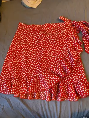 En röd fin kjol i storlek M . Men ganska liten i storleken. Är i fint skick och ser gansk ny ut.