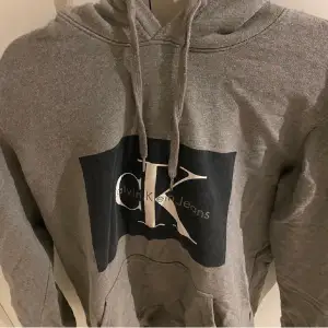 En fräsch och mysig Calvin Klein hoodie, i färgen grå, inte kommit till så mycket användning på senaste tid därav vill jag sälja den.