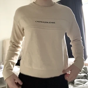 Calvin Klein tröja - Beige Calvin Klein tröja, köpte för ett år sedan men har aldrig använt. Pris kan diskuteras🫶🏼 Nypris va runt 700kr