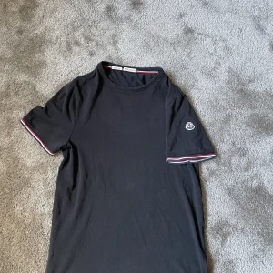 Moncler T-shirt  - Hej  säljer nu min Moncler T-shirt som jag har tröttnat på. Den är modell slim fit i S/xs. Självklart Äkta! Fint skick inga hål osv. Vid funderingar hör gärna av dig.  Vid snabb affär kan jag gå ner i pris.