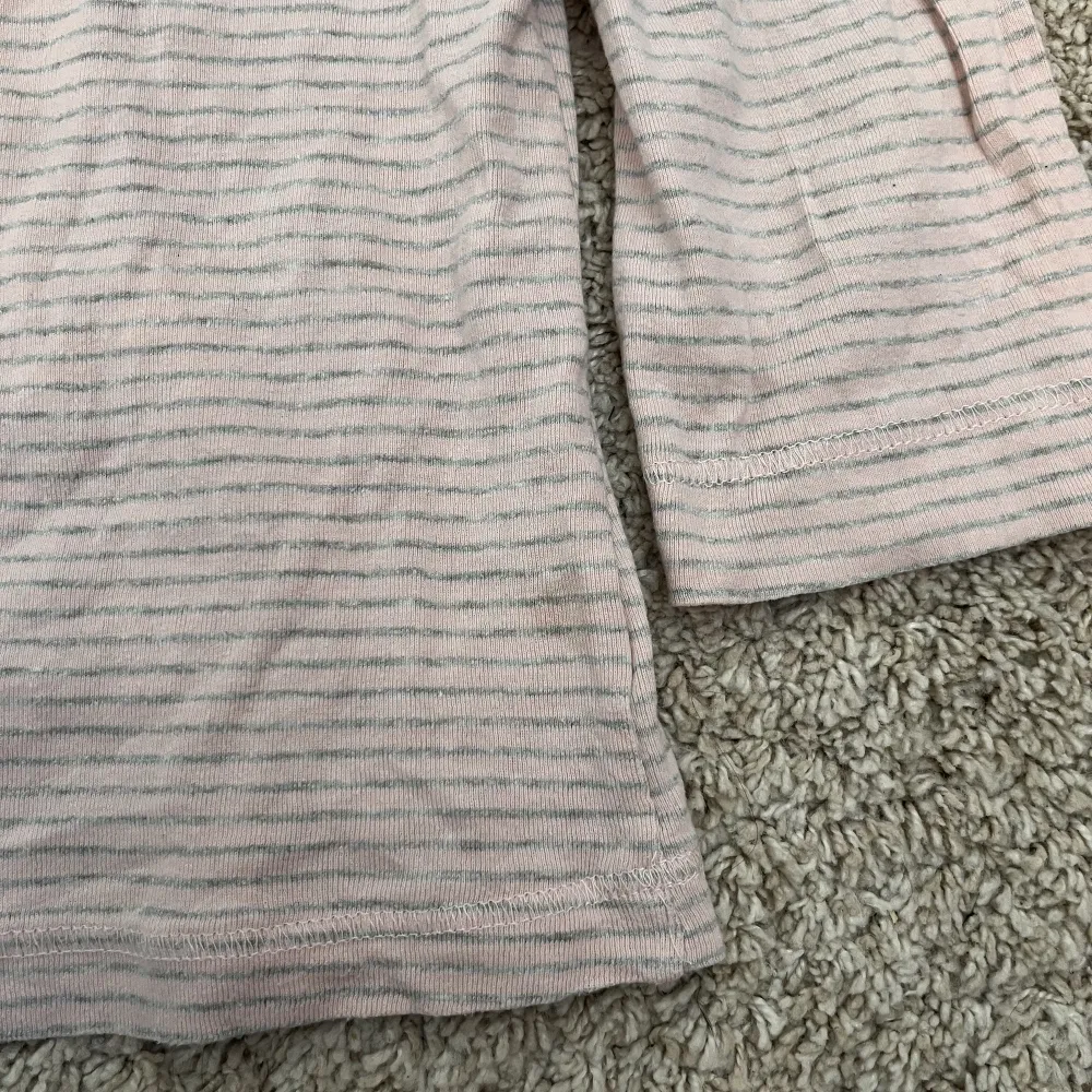 Söt rosa randig tröja med båtringning och trekvartsärmar. Storlek xs men passar även s/m vilket jag har på bilden. Liten fläck som knappt syns, visas på bild 3 . Toppar.