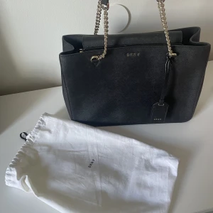 DKNY VÄSKA - Säljer denna fina väska. I gott sick med medföljande dustbag. Köparen står för frakt. 