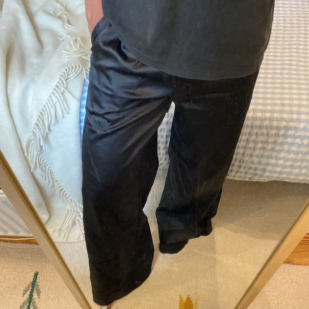 Svarta satinbyxor med vida ben som sitter perfekt i midjan. Byxorna är långa och helt i nyskick. Storleken är xs vilket ungefär är W28-32 L32 och de är ifrån Asos. Kan användas till vardagen eller passar perfekt som pyjamasbyxor . Farkut & Housut.