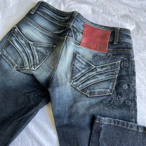 y2k Caprijeans <3 - Säjer mina supersnygga caprijeans för att dom tyvärr är för små för mig. De har detaljer av blommor samt dragkedjor vid slutet av byxan. De är i bra skick utan skador eller fläckar 💕 Använd köp nu och skriv om du har några funderingar. 🌼