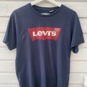 LEVI’S t-shirt - Blå t-shirt med röd Levi’s logga. Storlek medium