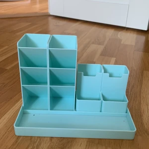 Ljusblått penställ  - Ett ljusblått penställ med två olika penförvarings modeller som man kan ställa på en platta🩵🩵Lite blyerts fläckar i här och där men går nog att få bort. Pris kan diskuteras