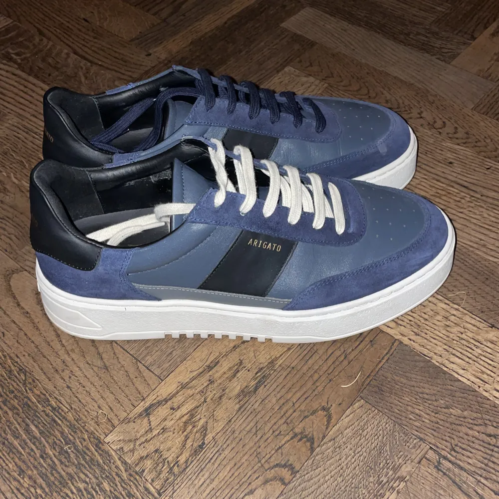 Helt nya Axel arigato skor i en marinblå färgkombination.  Köpa för 2800 Endast använda 3 gånger.  Medföljer både vita och marinblåa skosnören.  Kvitto finns.. Skor.