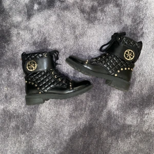 Boots - Ett par svarta boots med guld detaljer från märket Guess. De är väldigt varma och perfekta för vintern! Nypris: 1800kr Skriv privat för mer bilder och info.