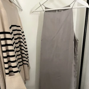 Klänning - En superfin ljusgrå klänning från H&M✨  Använd vid ett speciellt tillfälle✨ Klänningen är rätt lång, men täcker inte fötterna!  Kontakta mig vid fler frågor/ bilder!