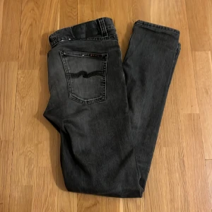 Nudie Jeans - Ett par väldigt schyssta Nudie Jeans i färgen svart/grå i en slimfit passform. Jeansen har inga som helst deffekter och är i ett bra skick. Nypris 1600. Hör av er för fler bilder eller om ni har frågor.