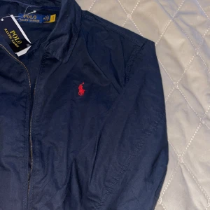 Ralph lauren jacka - Helt oanvänd marinblå jacka från Ralph lauren i storlek M. Säljer den åt min kille då han beställde fel storlek. Kan tänka mig gå ner i pris vid snabbt köp😃köptes för 2695 kr och säljer för 1250. Perfekt julklapp åt en kille