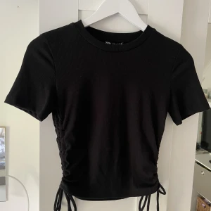 Svart topp - Svart topp med knytning på sidorna. Skönt material och snygg men är för liten för mig. Känns som storlek S. Väldigt bra till utgång/ fest!!😎💕💕