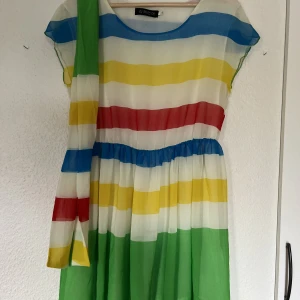 Klänning - Randig färgad klänning med justerbart tygstycke. Kan användas som sjal, knytas som rosett etc. Storlek XL, men passar som S/M. 