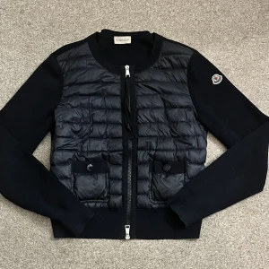 Moncler cardigan - Säljer min mörkblåa monclare cardigan som är super fin och passar till allt. Den är köpt för ca 2 år sen i Frankrike och är äkta! Hittar dock tyvärr inte kvittot men QR koden funkar🌸 den är i bra super bra skick.kan antingen frakta eller mötas up i Sthlm❤️
