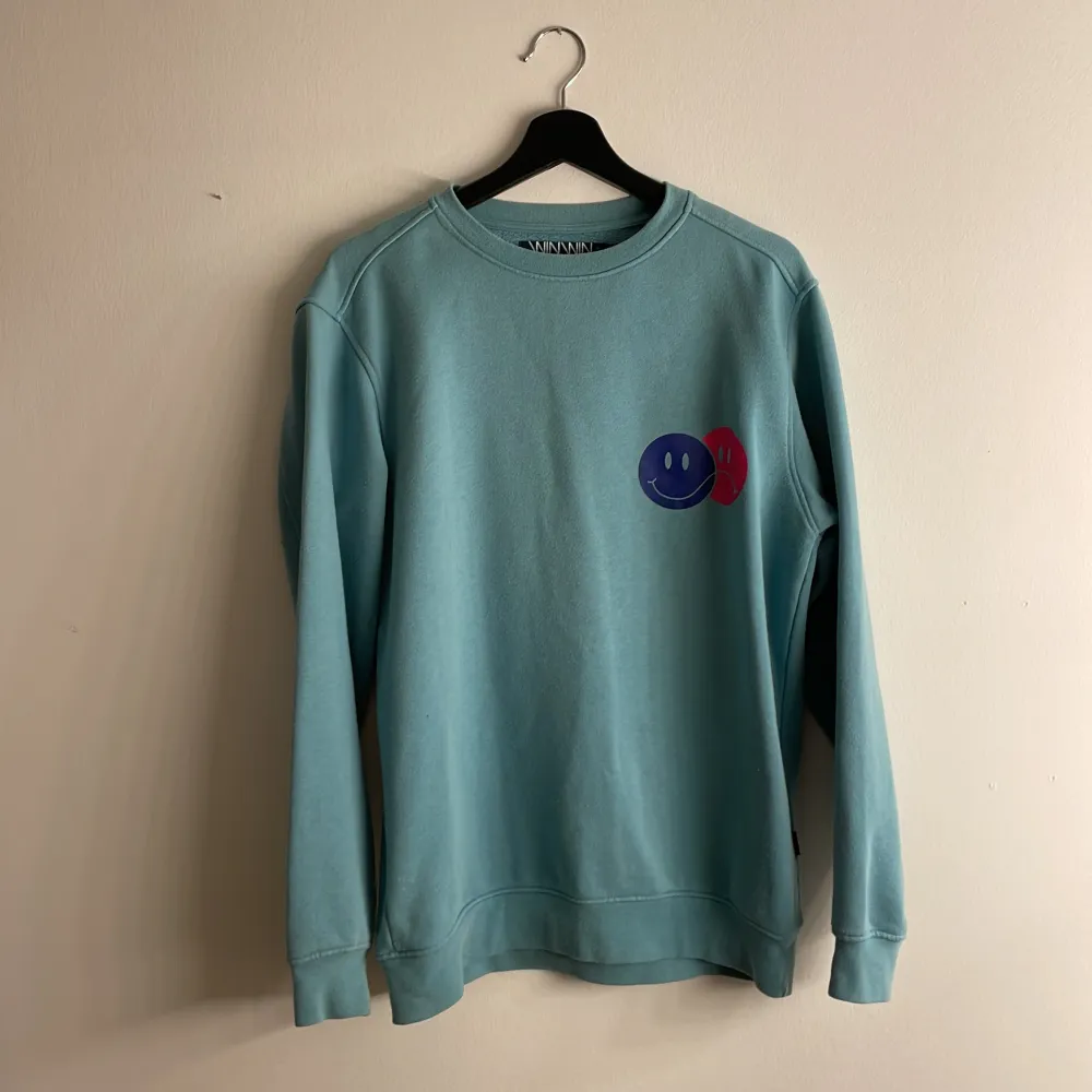 Säljer denna blå coola sweatshirt med två smileys på :) Säljer pga använder ej:/ Tror den är köpt på carlings, från märker WinWin. Storlek S, men är lite längre i modellen. Fler bilder? Skriv💙🦋🐠. Tröjor & Koftor.