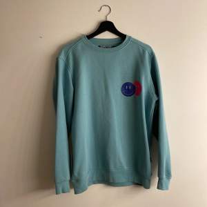 Säljer denna blå coola sweatshirt med två smileys på :) Säljer pga använder ej:/ Tror den är köpt på carlings, från märker WinWin. Storlek S, men är lite längre i modellen. Fler bilder? Skriv💙🦋🐠