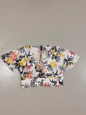 Topp - Blommig topp perfekt till sommaren.  V-form i framsidan och öppen i ryggen så man kan knyta den😊 Priset kan diskuteras 