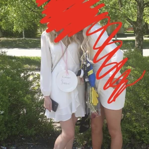 Studentklänning - Vit klänning från A.X Paris storlek Xs/S. Använt en gång men har en liten fläck på baksidan av ärmen men annars väldigt fint skick. Har dragkedja i ryggen.