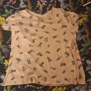 Ljus rosa/beige T-shirt  - Rosa/begie kortärmad T-shirt från Kappahl med kaktus figurer på bak och framsidan använd ett par gånger 😊