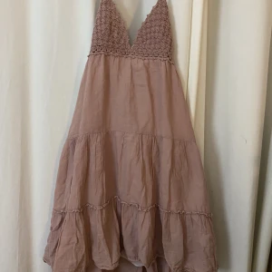 Öppen rygg sommarklänning - Rosa sommarklänning med öppen rygg. Svalt tyg och justerbara band både runt nacke och på ryggen. 