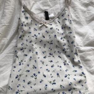 Linne med blå blommor  - Ett fint linne från HM med blå blommor på. Säljer pågrund den kommer inte tillandvändning. 