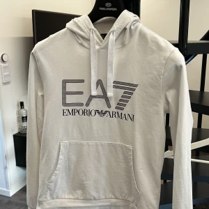 EA7 hoodie vit - XS - Säljer min vita EA7 Emporio Armani hoodie i storlek XS. Hoodien är i nyskick och är använd cirka 5 gånger då den är för liten för mig. Kostar 900kr ny. 