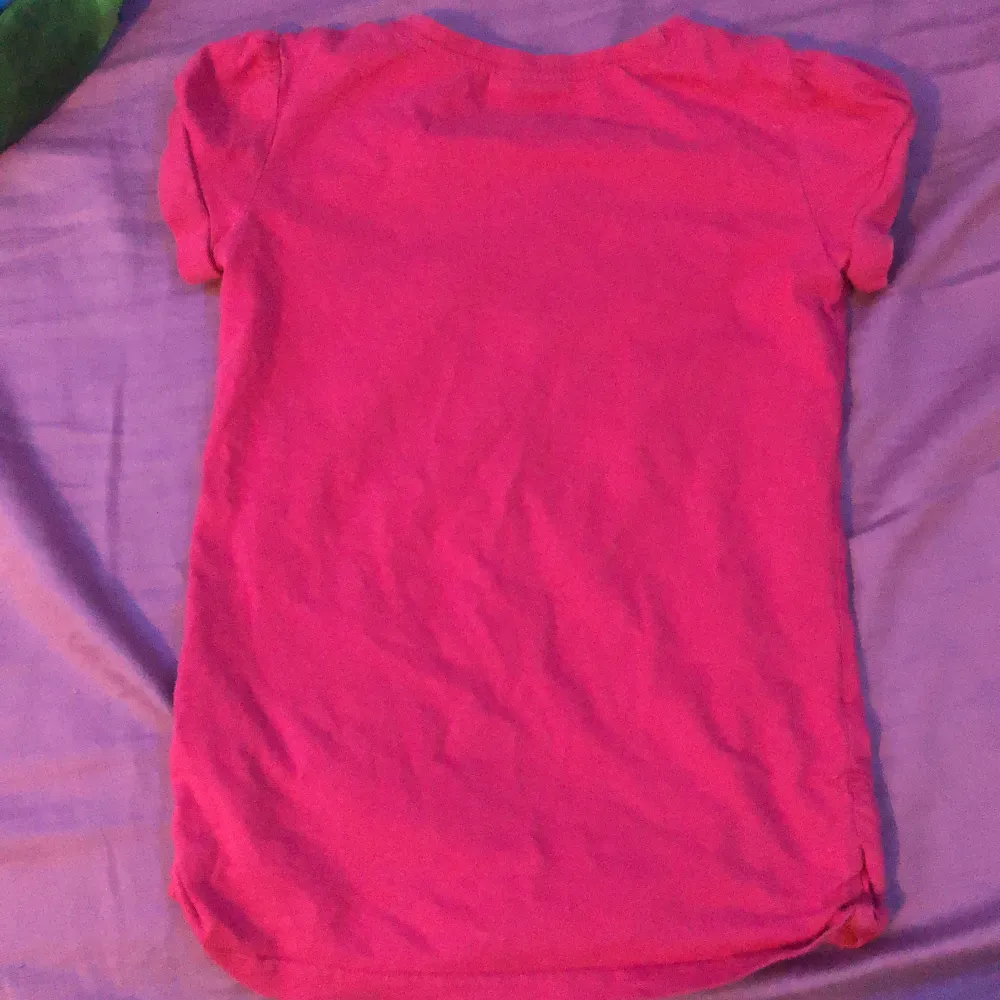 En jättefin rosa tröja med något grafiskt på, lite för liten för mig därför säljer jag den. . T-shirts.