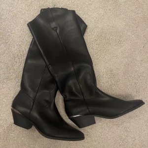 Stövlar  - Ett par svarta lite cowboy inspirerande stövlar med silver ditalj bak till  från pull & bear.  Dom har endast användas 1 gång ute och är i storlek 39