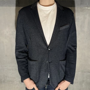 Kavaj -  kavaj i färgen grå. Storlek L och modellen på bilden är 186 cm. Fint skick, inga skavanker. Köp för endast 329kr.