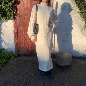 Stickad långklänning - Stickad vit klänning med rutig mönster från NAKD i mycket bra skick, bara använd 1 gång. 