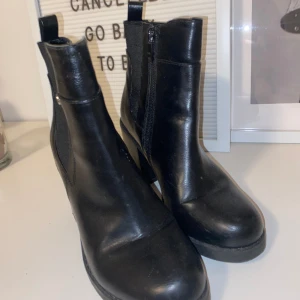 Svarta Boots med klack - Säljer ett par svarta boots med klack. Knappt använda. Storlek 38 OBS: köparen står för frakten. (Annons finns ute på andra hemsidor.)