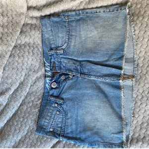 Lådmidjad jeanskjol - Vintage lågmidjad jeanskjol, fickor bak och fram, knäppning med 3 knappar, kortare modell, sitter tajt om du har lite större höfter 