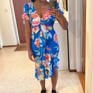 Lipsy London - Snygg klänning från Lipsy London med volanger fram. Endast använd 1 gång. 