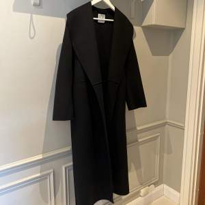 Lång svart kappa ifrån Toteme, storlek 32. Endast använd 1 gång så den är som ny. 