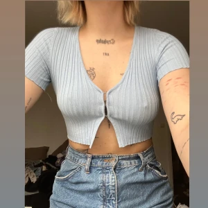 crop-top  - så gullig baby-blue croppad t-shirt från bershka med små ”hakar” som håller ihop tröjan (man kan knäppa av dom om man vill).  skriv för mer info 💙🫶🏼
