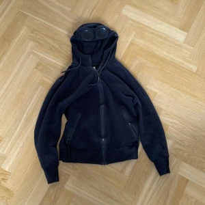Cp company hoodie  - Zip hoodie från cp company med googles. Fint skick och väldigt bra svart färg som passar till alla outfits speciellt om du vill se unik ut. Säljer den eftersom att jag har vuxit ur den.