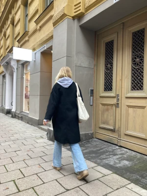 Kappa - Svart kappa köpt från Sellpy men original från HM, storlek 38💛🧡lite nopprig och i använt skick! Fungerar både som höst/vinterkappa och tidig vårjacka! Jag är 177 och den är knälång på mig🫶🏼