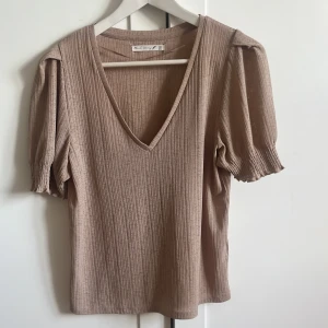 Beige blus med fina detaljer.  - En beige blus i strl XS men rymlig så mer som en S. Skicket är fint. 