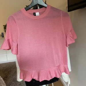 Tröja - Supersöt rosa stickad T-shirt, volang vid ärmarna samt längst ner, bra skick och använd ca tre gånger💕 Skriv för mer bilder!
