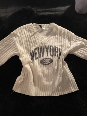 Kabelstickad tröja med tryck - Oversized kabelstickad tröja med trycket ”newyork”