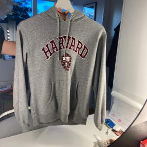 En grå hoodie från H&M med tryck ”Harvard” Vädligt skön och snygg, storlek XS passar nog S också. Hör av er vid frågor eller undringar 🩶🩶