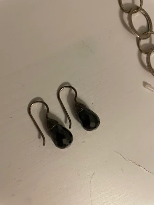 Svarta kristall örhängen - Örhängen med svart blänkande sten. Så snygga och eleganta. Enkla att styla.