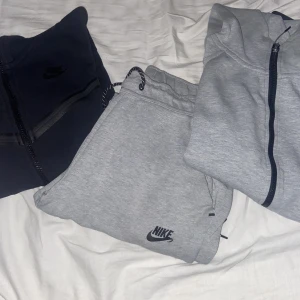 Grå Nike tech dress + Svart Nike tech kofta - Grå Nike Tech dress i god skick utan några fel eller fläckar. Tröjan passar även stl M  Svart nike tech kofta utan några fel eller fläckar.  Kan även bytas mot en annan vara som passar.