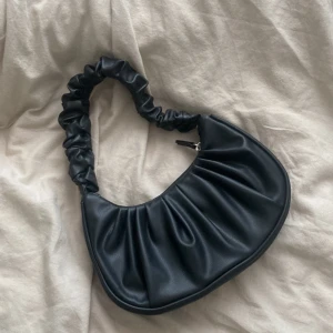 Väska från h&m - Använd 3-4 gånger, svart liten handväska från h&m, litet förvaringsfack i väskan